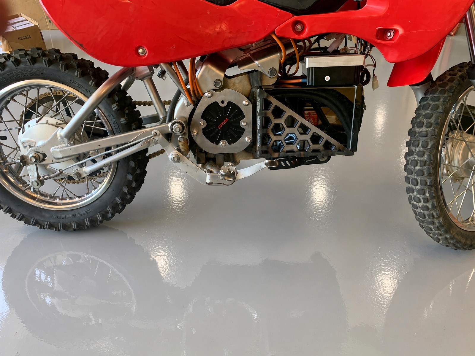Electric motor, controller and welded aluminum battery tray installed in the swingarm bay of a converted 110cc pit bike